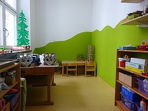 Der Werkraum, grüne Berge an der Wand, Fenster links